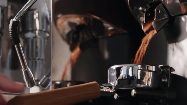 Slow motion fresh ground coffee fall into basket of bottomless portafilter