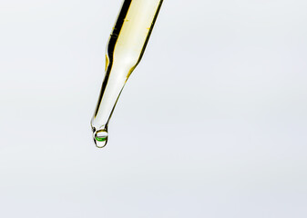 Close up view of glass pipette droplets on white background.