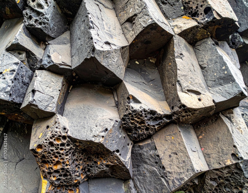Poster close up view of dark gray hexagonal basalt columns stone texture background