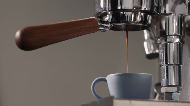 Slow motion espresso brew into blue ceramic cup
