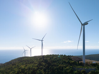 Wind turbines on the top of the mountain with sea on a background