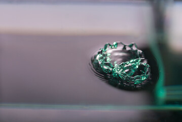 269.Green water drop crown on a dark surface