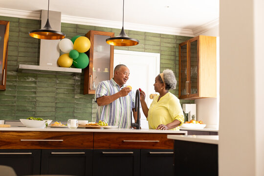 Senior couple enjoying breakfast together in modern kitchen, smiling and chatting