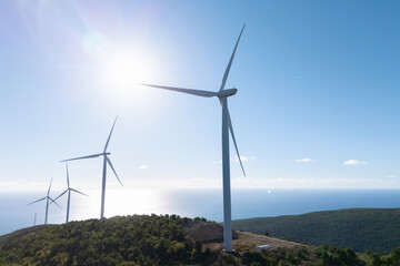 Wind turbines on the top of the mountain with sea on a background