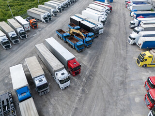Aerial view of a large truck parking lot at a logistics hub, with multiple commercial semi trucks parked in organized rows