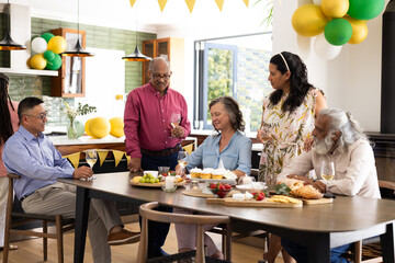 Seniors enjoying lively conversation and drinks at festive indoor party