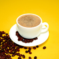 cup of coffee with coffee beans closeup view on yellow background 