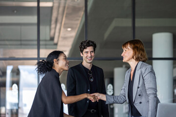 Business team from diverse cultures, genders, and generations celebrate the success hitting targets. Group of office workers express their appreciation to each other at the balcony. Cross generations
