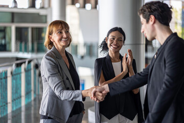 Business team from diverse cultures, genders, and generations celebrate the success hitting targets. Group of office workers express their appreciation to each other at the balcony. Cross generations
