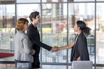 Business team from diverse cultures, genders, and generations celebrate the success hitting targets. Group of office workers express their appreciation to each other at the balcony. Cross generations
