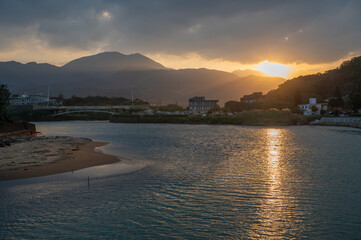 sunset time nearby the estuary, sunlight shines on the wave of sea, in New Taipei City, Taiwan.
