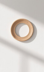 Minimalist top view of a round wooden tray on a white surface with natural light and soft shadows, embodying a serene wabi-sabi aesthetic
