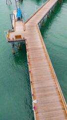 Aerial view of a wooden pier with vibrant flowers.