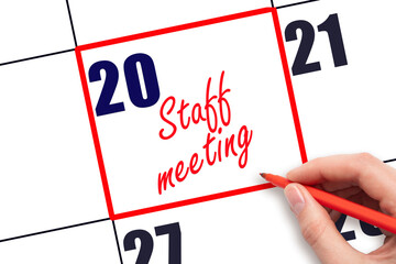 20 th day of the month.  Hand writing Staff meeting reminder and drawing red frame on calendar with red pen on white background. Business concept. Planning and scheduling