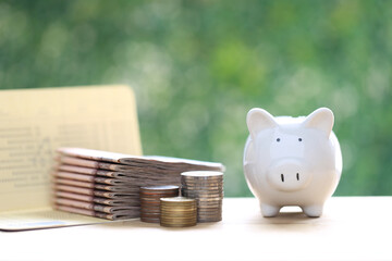 Piggy bank and banking account book on natural green background, Save money for prepare in future and pension retirement concept