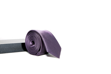 Slim fit black tie rolled on white background close-up view 