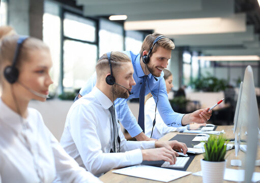 Phone operator working at call centre office helping hiss colleague.