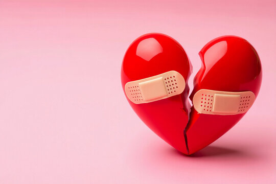 A broken red heart is mended with a bandage, symbolizing healing after emotional pain or loss.