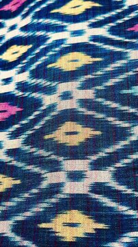 Handwoven ikat textile featuring colorful geometric patterns. Perfect for backgrounds, fashion, interior design, and cultural themes.