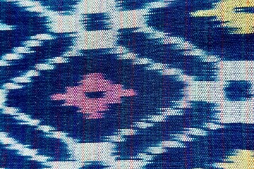 Handwoven ikat textile featuring colorful geometric patterns. Perfect for backgrounds, fashion, interior design, and cultural themes.