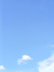 Minimal style background image, clear sky with few floating clouds, beautiful and natural. A clear blue sky with natural floating clouds, suitable for use in graphic design and advertising.