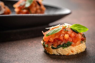 Close-up of Italian bruschetta with tomatoes, basil, and parmesan on toasted bread