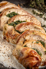Sliced chicken roll with spinach and bacon in creamy sauce