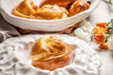 Freshly baked sweet bun on white plate