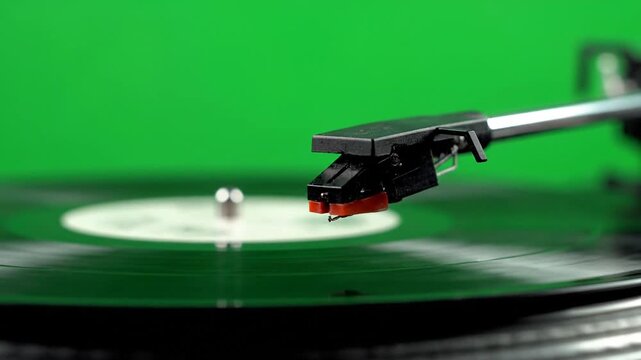 A record players tonearm lifts  on green screen