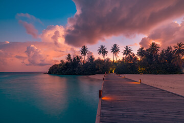 Majestic sunset over tropical ocean beach bay with pier lights in Maldives island, perfect palm tree silhouettes, calm seascape, colorful sky, serene ocean horizon, ideal tropical paradise vacation