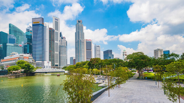 Singapore's Marina Bay financial district, where modern skyscrapers meet the wooden waterfront boardwalk, reflecting urban prosperity, economic strength, and commitment to sustainable growth.