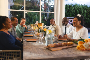Seniors enjoying dinner together, sharing laughter and stories at outdoor gathering
