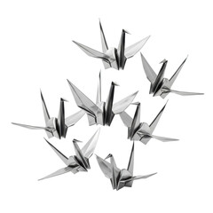 Delicate cluster of intricately folded, gleaming silver origami cranes, meticulously crafted and uniquely posed against a pristine transparent studio background, Concept of delicate artistry and