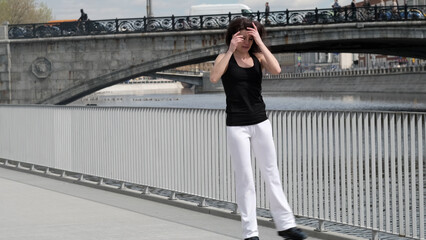 A fit woman practices with jumping shoes along a riverside, highlighting dynamic movement in an urban environment. The merging of modern fitness tools with city scenery reflects the adaptability of