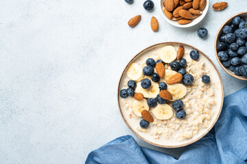 Oatmeal porridge with bananas, nuts and blueberries. Top view.
