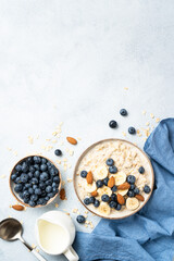Oatmeal porridge with milk, bananas and blueberries. Top view.