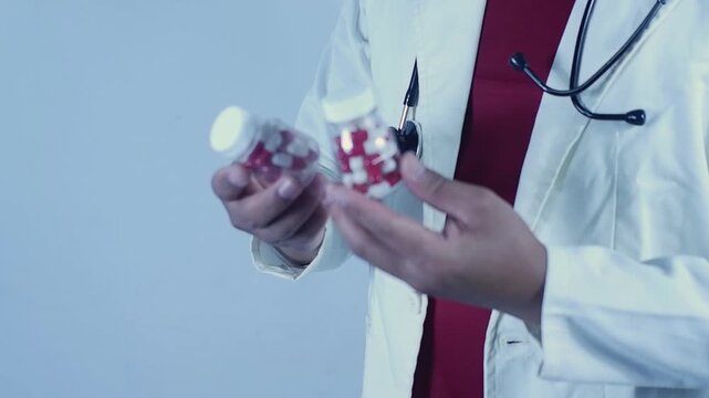 Doctor holding pills in a bottle. Preparing and recommending medication to a patient.