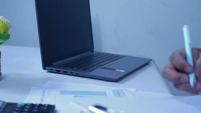 Businesspeople or office workers check sales charts, calculate with a calculator, and then write them down on a spreadsheet. Checking and auditing.