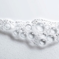 Close-up of translucent bubbles forming a wave-like pattern atop a white, foamy surface
