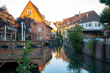 Naklejka premium Sunlit Canals of Colmar at Sunrise in the Old Town