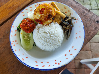 Tempong rice, Tempong rice is equipped with fresh vegetables, salted fish, eggs, chili sauce, tempeh, tofu and other accompaniments. Tempong rice is a typical food from Banyuwangi, Indonesia.