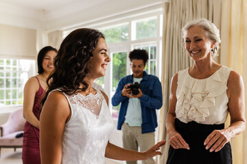 Capturing joyful wedding moments, bride in elegant dress smiling with family