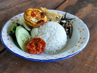 Tempong rice, Tempong rice is equipped with fresh vegetables, salted fish, eggs, chili sauce, tempeh, tofu and other accompaniments. Tempong rice is a typical food from Banyuwangi, Indonesia.