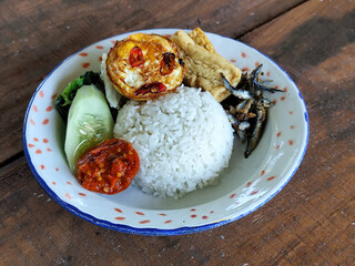 Tempong rice, Tempong rice is equipped with fresh vegetables, salted fish, eggs, chili sauce, tempeh, tofu and other accompaniments. Tempong rice is a typical food from Banyuwangi, Indonesia.