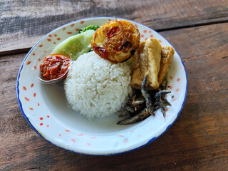 Tempong rice, Tempong rice is equipped with fresh vegetables, salted fish, eggs, chili sauce, tempeh, tofu and other accompaniments. Tempong rice is a typical food from Banyuwangi, Indonesia.