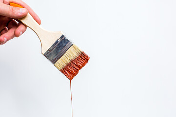 Paintbrush with dripping red paint isolated over white background