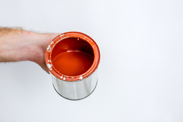 Red paint flowing down from can on white background