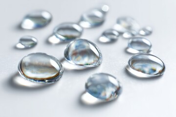 Clear water droplets on a light surface