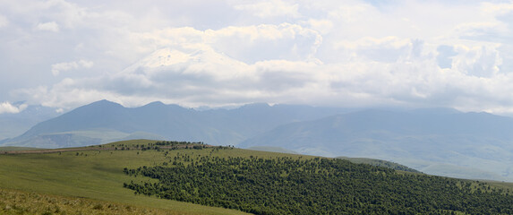 panorama with Elbrus mountain in the Caucasus between clouds