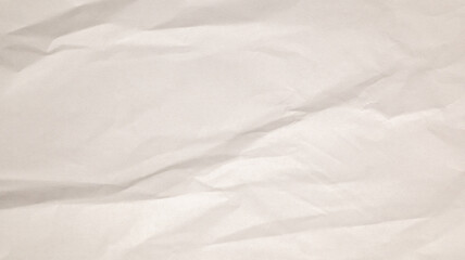 A textured surface of crumpled white paper showcases natural light creating softness and subtle shadows. Ideal for backgrounds or artistic projects focusing on simplicity